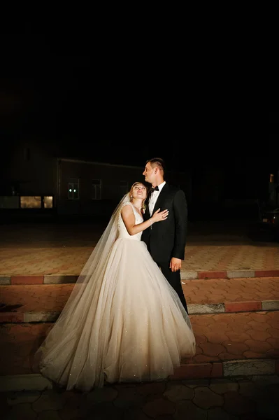 Fabulous bruidspaar poseren buiten 's nachts. — Stockfoto