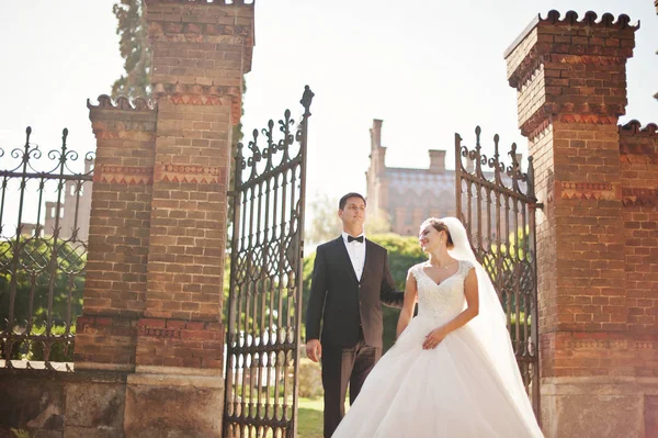 Appena sposati coppia posa accanto ai cancelli sul loro matrimonio d — Foto Stock