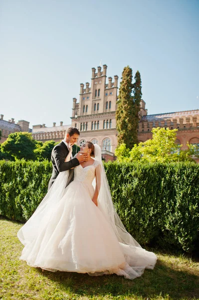 Couple de mariage attrayant posant dans le jardin d'un homme majestueux — Photo