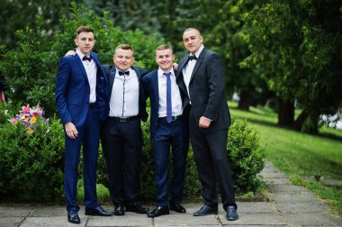 Poz smokin ve dört zeki ve yakışıklı mezunları