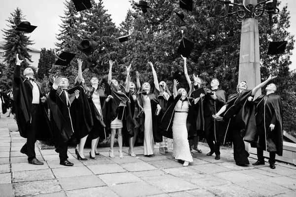 Happy university graduates throwing their graduation caps into t