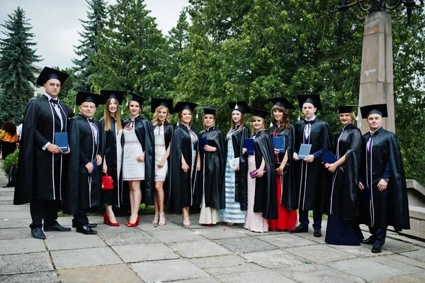 Mezunlarının mezuniyet ve outd poz kapaklar büyük grup