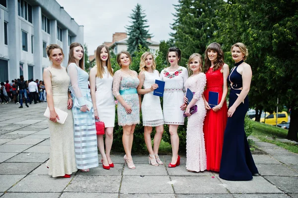 Faulous young women graduates in chic evening gowns posing outsi — Stock Photo, Image