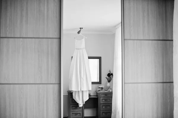 Vestido de noiva pendurado na prateleira da sala. Preto e branco p — Fotografia de Stock