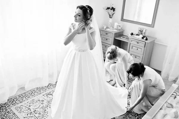 Damas de honra ajudando linda noiva para vestir-se e prepare-se para — Fotografia de Stock