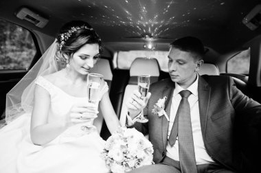 Yeni evli çift thei üzerinde Sedan içinde şampanya içmek