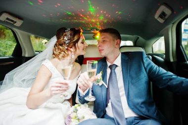 Yeni evli çift thei üzerinde Sedan içinde şampanya içmek