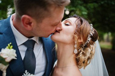 Parkta öpüşme bir düğün çift yakın çekim fotoğraf.