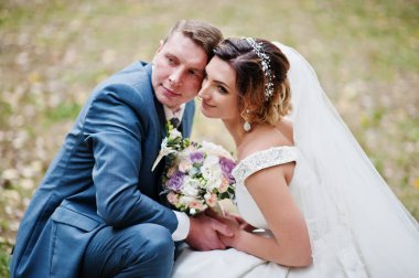 Park o çimlere oturup muhteşem genç Düğün çifti