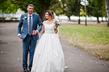 Güneşli da parkta poz muhteşem genç Düğün çifti