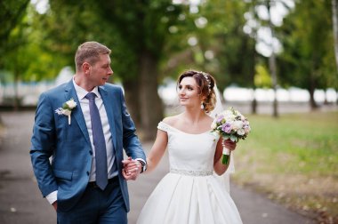 Güneşli da parkta poz muhteşem genç Düğün çifti