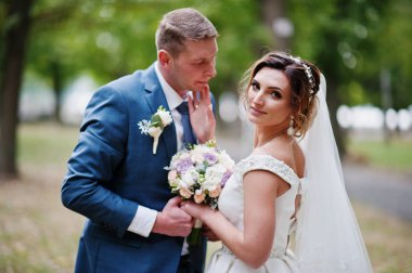 Güneşli da parkta poz muhteşem genç Düğün çifti