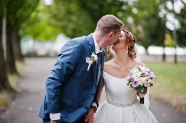 Güneşli da parkta poz muhteşem genç Düğün çifti