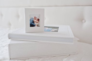 Şık düğün photobooks veya fotoğraf albümleri beyaz yatakta geri