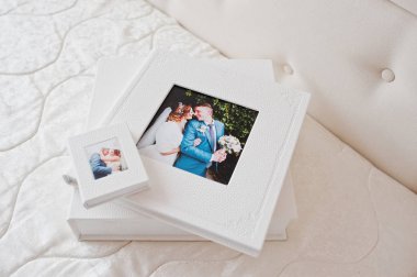 Şık düğün photobooks veya fotoğraf albümleri beyaz yatakta geri