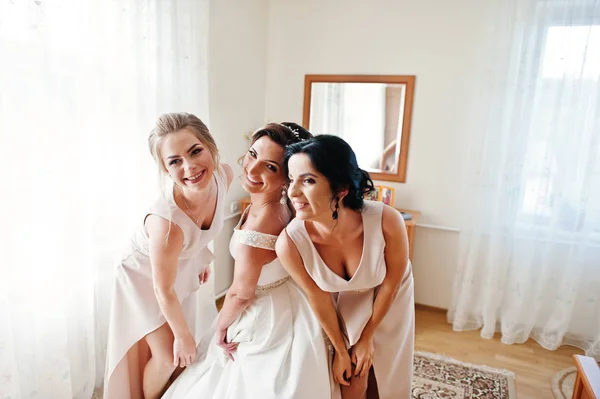 Fabuloso jovem noiva posando com suas noivas em seu quarto em — Fotografia de Stock