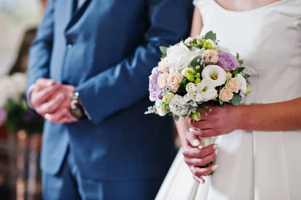 Bride holding a wedding bouquet during the ceremony in the churc — Stock Photo, Image