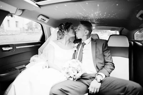 Oturma ve limuzin içinde öpüşme fantastik Düğün çifti. B