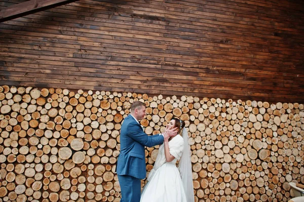 Perfeito casal recém-casado posando no fundo de madeira . — Fotografia de Stock