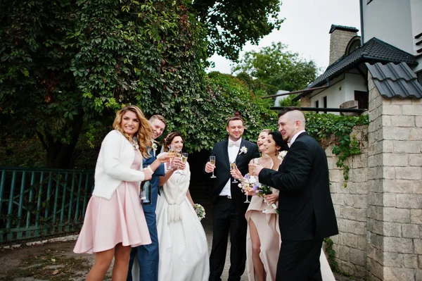 Casamento casal, damas de honra e padrinhos bebendo champanhe fora — Fotografia de Stock