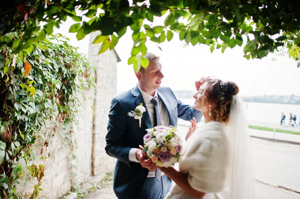 Casal de casamento impressionante andando no parque com lago nas costas — Fotografia de Stock