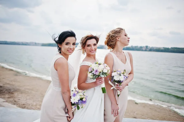 Noiva deslumbrante com damas de honra bonitas posando com buquês em t — Fotografia de Stock