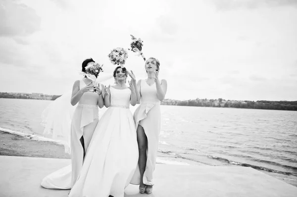 Noiva deslumbrante com damas de honra bonitas posando com buquês em t — Fotografia de Stock