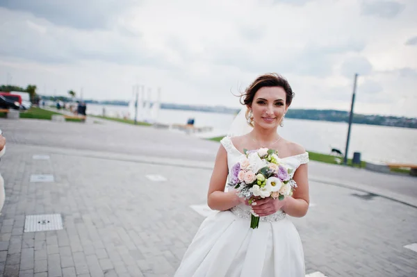 Portrait of a stunning bride posing on the lakeside with a weddi — Stock Photo, Image