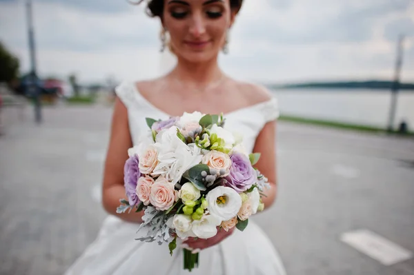Портрет потрясающей невесты, позирующей на берегу озера со свадьбой — стоковое фото