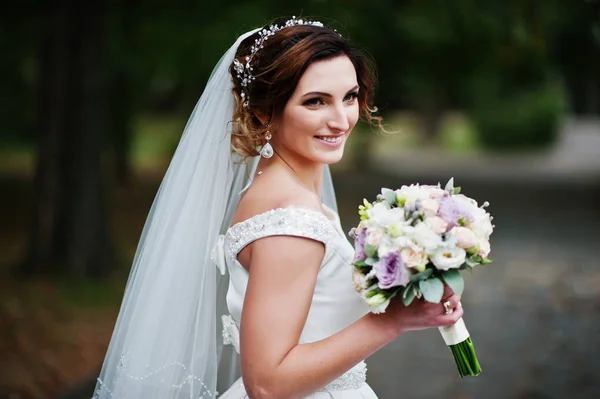 Portrait d'une jeune mariée attrayante marchant dans le parc sur son — Photo