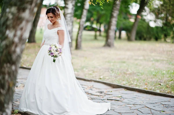 Portrait of an attractive young bride walking in the park on her — Stock Photo, Image