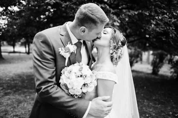 Parkta öpüşme bir düğün çift yakın çekim fotoğraf. Siyah bir