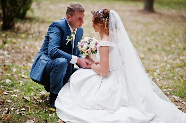 Park o çimlere oturup muhteşem genç Düğün çifti