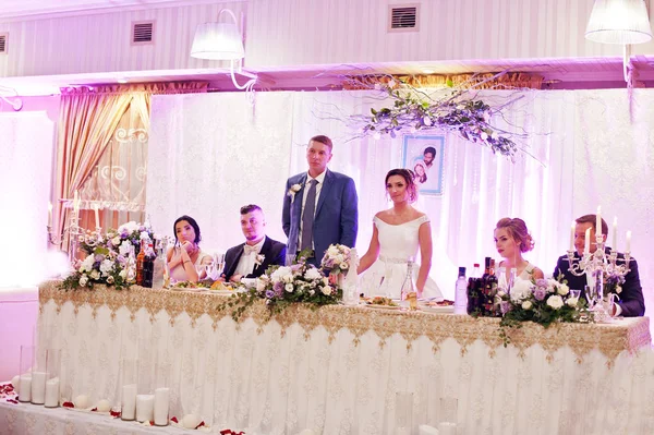 신부 들러리와 그들의 테이블에 서 있는 아름 다운 웨딩 커플 — 스톡 사진