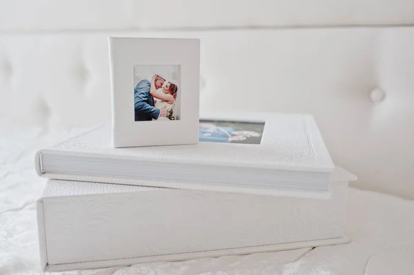 Elegante Hochzeits-Fotobücher oder Fotoalben auf dem weißen Bettrücken — Stockfoto