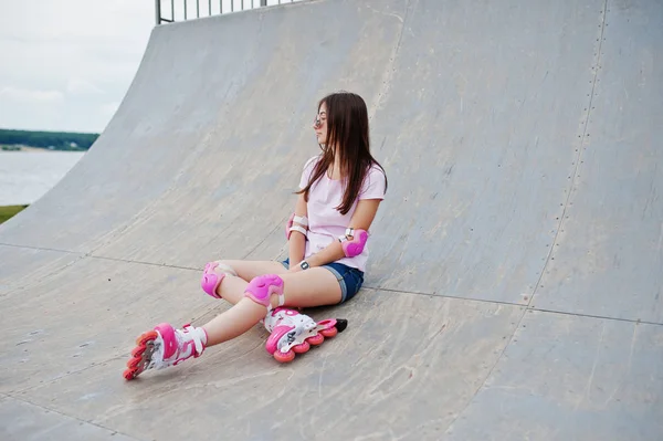 Retrato de uma linda garota sentada no rollerbladin ao ar livre — Fotografia de Stock