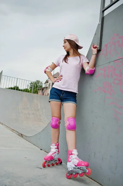 Gut aussehende junge Frau mit Mütze, T-Shirt und Shorts posiert in — Stockfoto