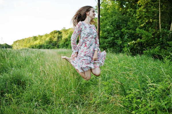 Retrato de uma jovem deslumbrante em vestido pulando no prado — Fotografia de Stock