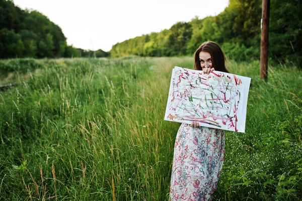 Retrato de uma bela jovem mulher artsit segurando sua pintura em — Fotografia de Stock