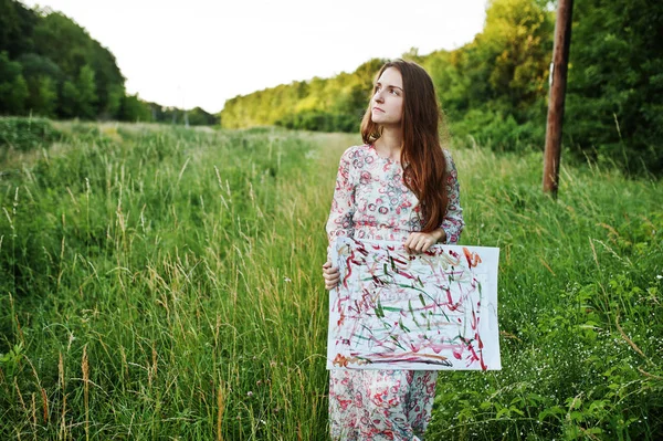 Retrato de uma bela jovem mulher artsit segurando sua pintura em — Fotografia de Stock