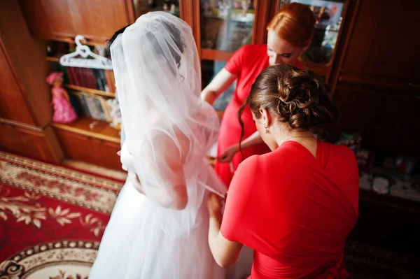 Damas de honra úteis ajudando noiva a vestir-se e prepare-se para — Fotografia de Stock