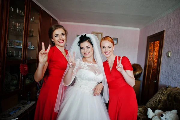 Braut posiert am Hochzeitstag mit Brautjungfern im Zimmer. — Stockfoto