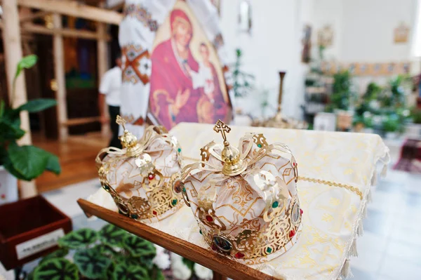 Golden crowns standing on the table in the church for wedding ce — Stock Photo, Image