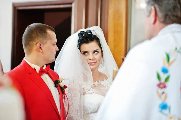 Свадебная пара, стоящая в церкви в присутствии священника — стоковое фото