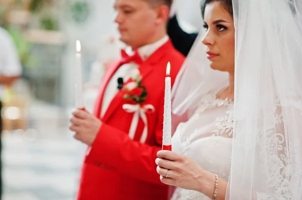 Foto de primer plano de la novia y el novio sosteniendo velas en la iglesia — Foto de Stock