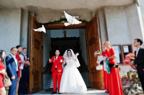 Gorgeous wedding couple releasing wedding white doves into the a