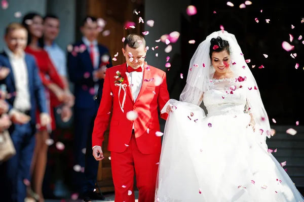 Fantastische bruidspaar lopen van de kerk en mensen thr — Stockfoto