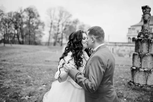 Beau couple de mariage marchant et s'embrassant à côté de la vieille fou — Photo