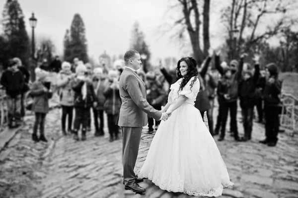 Prachtige bruidspaar houden handen op de stoep terwijl kraai — Stockfoto