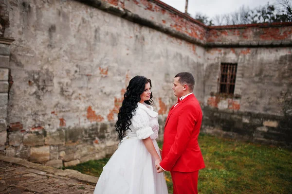 Schönes Hochzeitspaar posiert im Hof eines alten Schlosses — Stockfoto